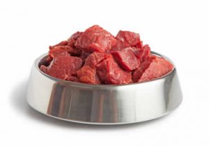 Raw beef meal in bowl, fresh, natural food for dog or cat, isolated on white background.